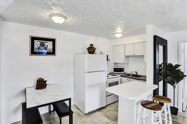 a kitchen with a refrigerator a stove a microwave and dining table