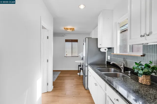 a kitchen with a sink and a stove with wooden floor