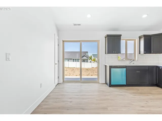 a view of a kitchen with kitchen island and stainless steel appliances