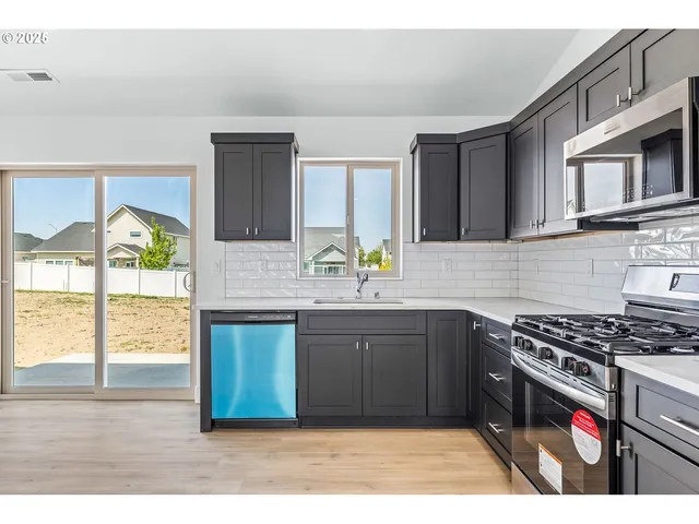 a kitchen with stainless steel appliances granite countertop a stove and a sink