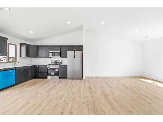 a large white kitchen with cabinets and a wooden floor
