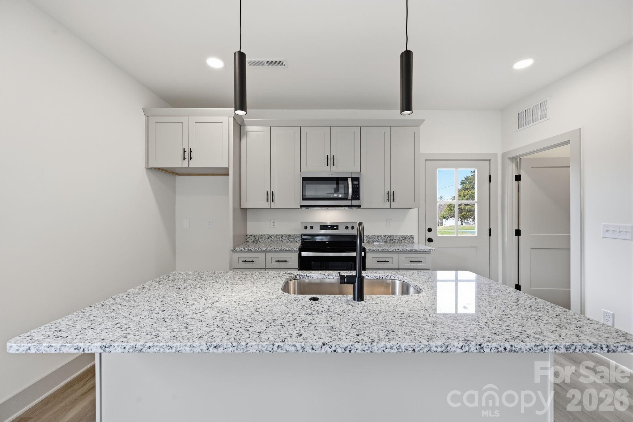 509 Beard Street Monroe, NC 28110 - Photo 12 of 33 a kitchen with kitchen island a counter top space appliances and cabinets