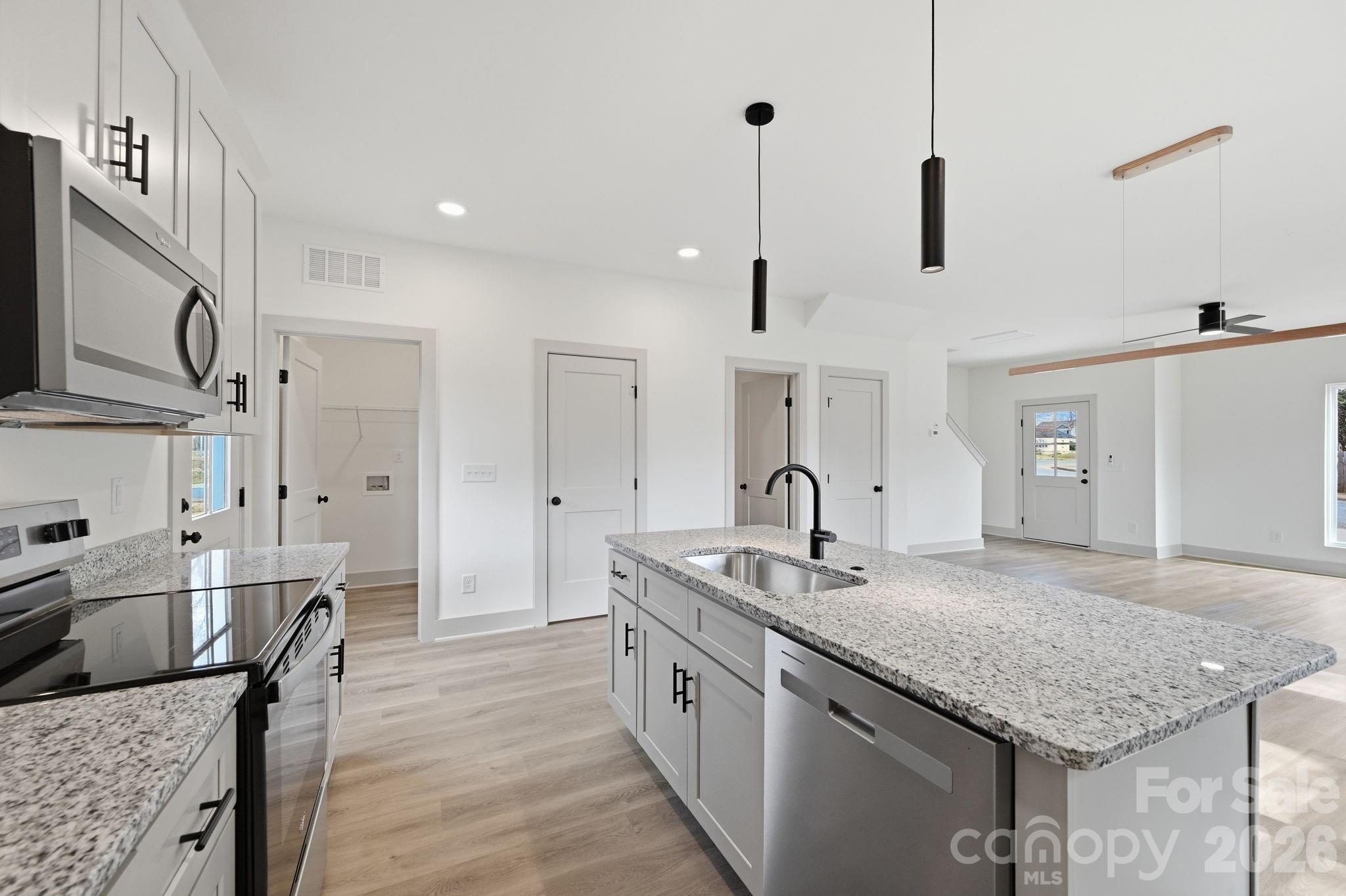 509 Beard Street Monroe, NC 28110 - Photo 14 of 33 a kitchen with stainless steel appliances granite countertop a sink a refrigerator and wooden floor