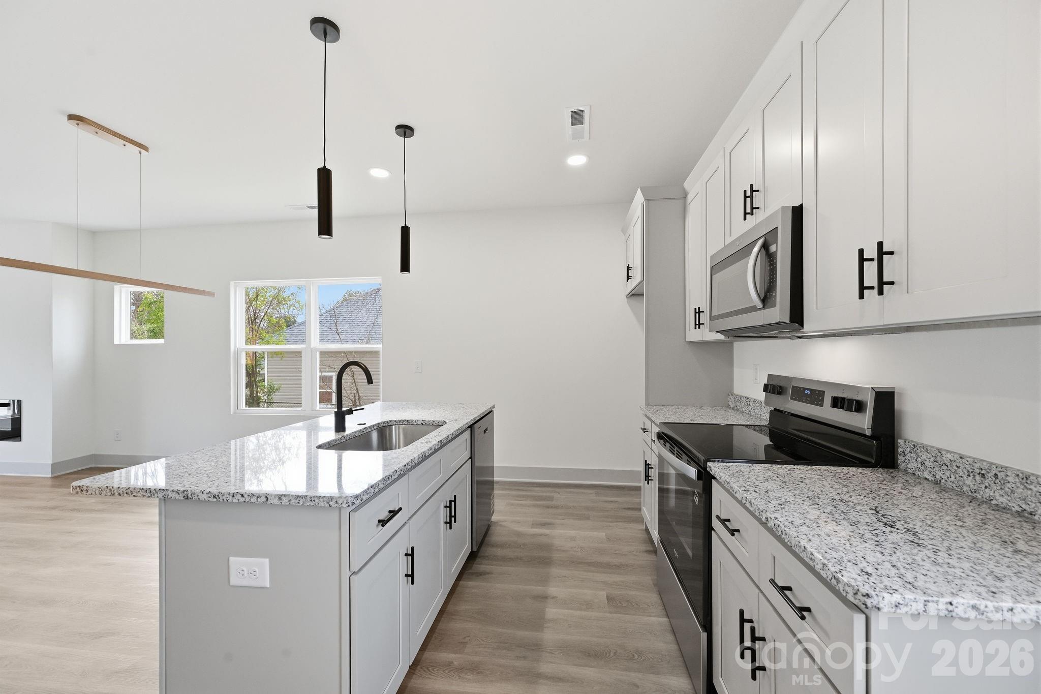 509 Beard Street Monroe, NC 28110 - Photo 15 of 33 a kitchen with stainless steel appliances granite countertop a sink stove and cabinets