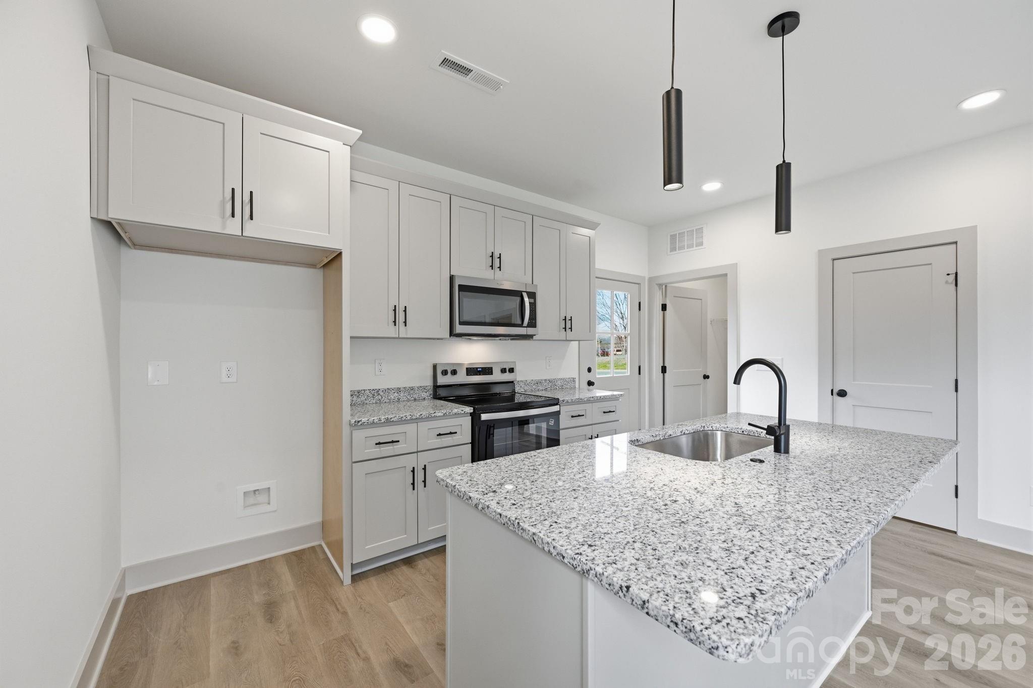 509 Beard Street Monroe, NC 28110 - Photo 16 of 33 a kitchen with granite countertop a stove a sink and a refrigerator