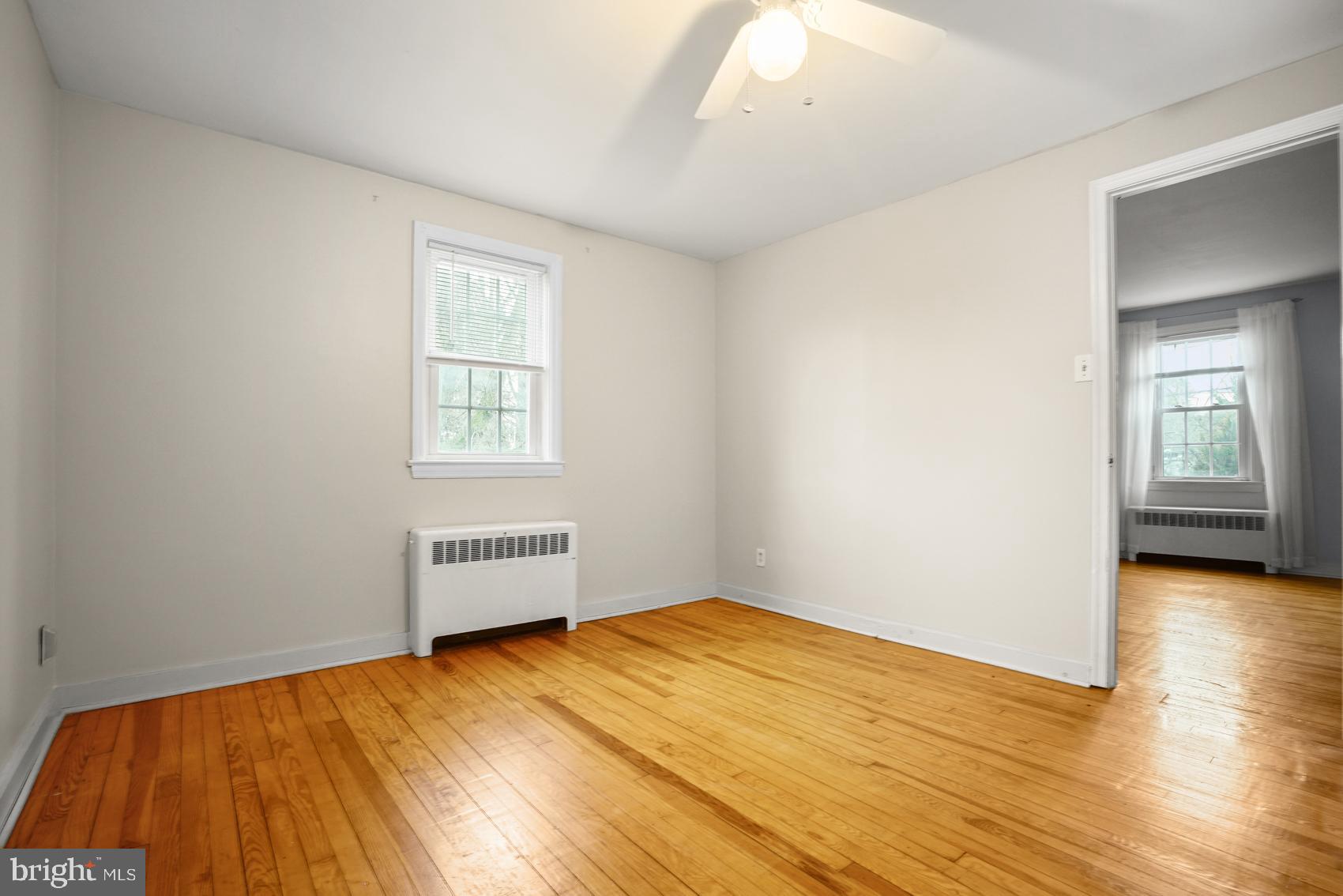 919 Valley Forge Road, Unit 1 Phoenixville, PA 19460 - Photo 12 of 25 an empty room with wooden floor and windows