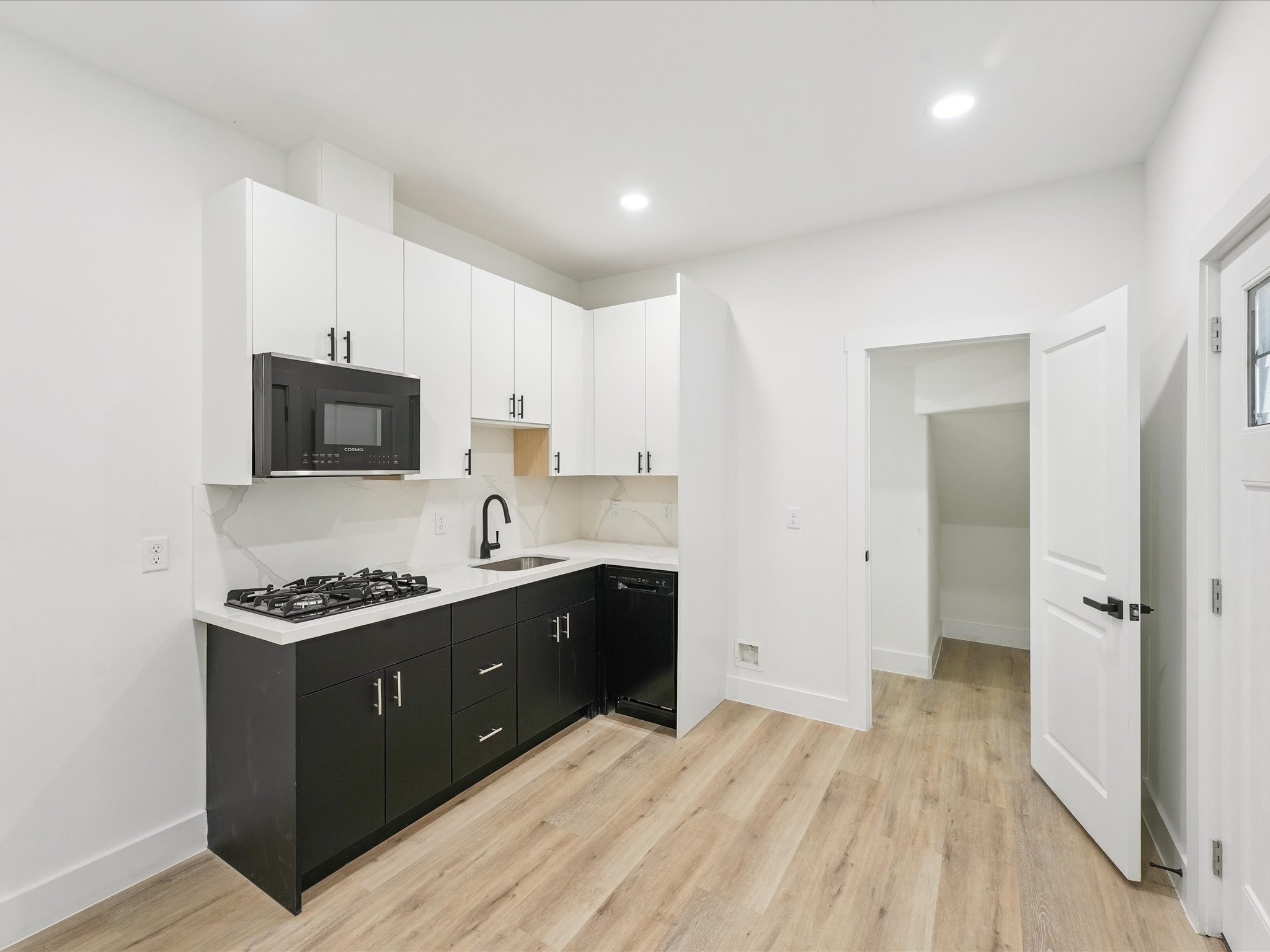 3510 Saltus Street Houston, TX 77003 - Photo 9 of 36 a kitchen with a sink and a stove top oven with wooden floor