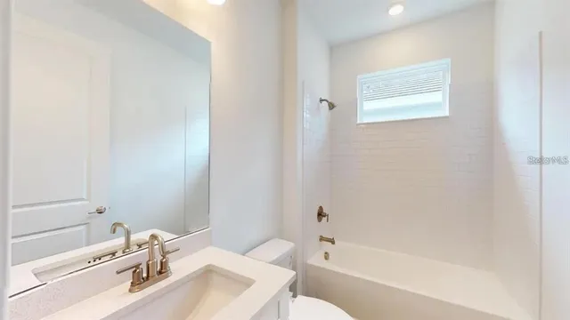 a bathroom with a tub sink toilet and a mirror