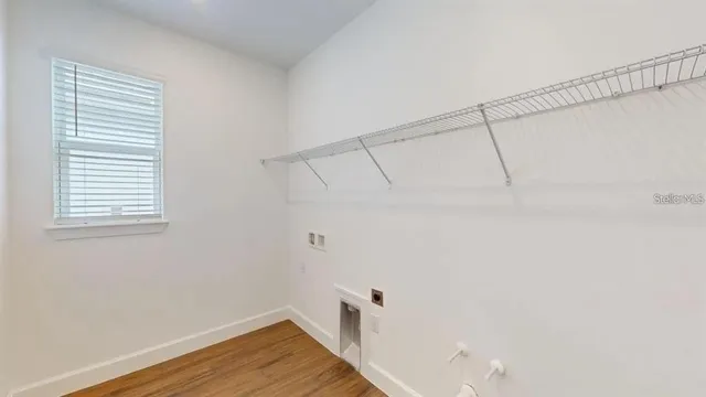 a view of a room with wooden floor and brick walls