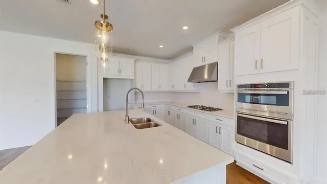 a kitchen with stainless steel appliances granite countertop a stove and a sink