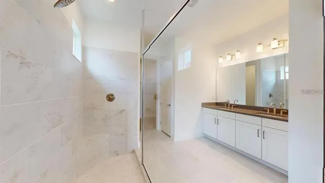 a bathroom with a granite countertop sink a mirror and a shower