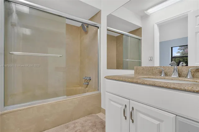 a bathroom with a granite countertop sink a toilet and a mirror
