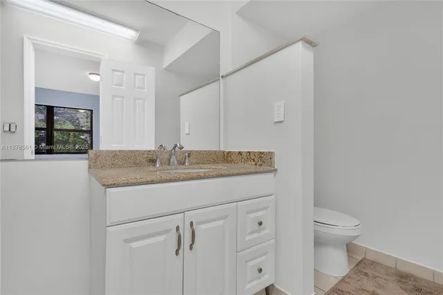 a bathroom with a granite countertop sink and a mirror