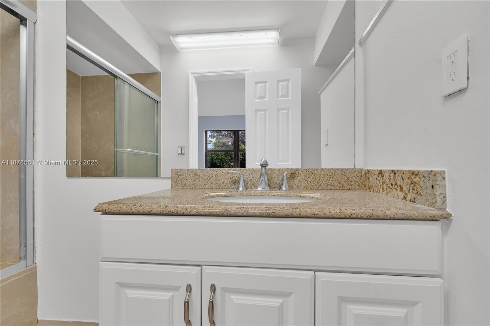 9355 Southwest 8th Street, Unit 425 Boca Raton, FL 33428 - Photo 23 of 42 a bathroom with a granite countertop sink and a mirror