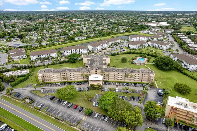 an aerial view of a city with lots of residential buildings lake and mountain view in back