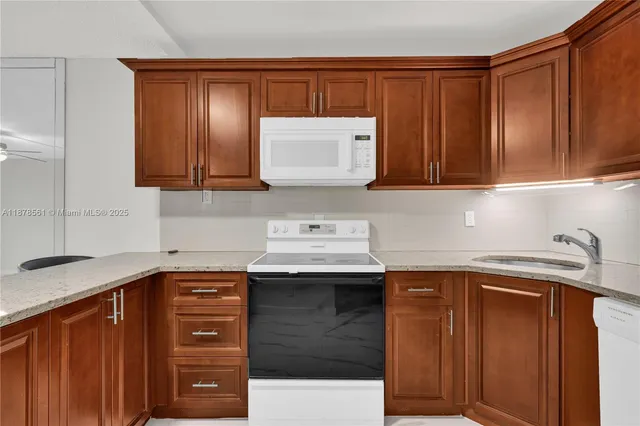 a kitchen with stainless steel appliances granite countertop a sink stove and cabinets
