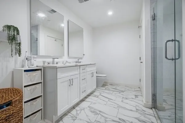 a bathroom with a sink a toilet and shower