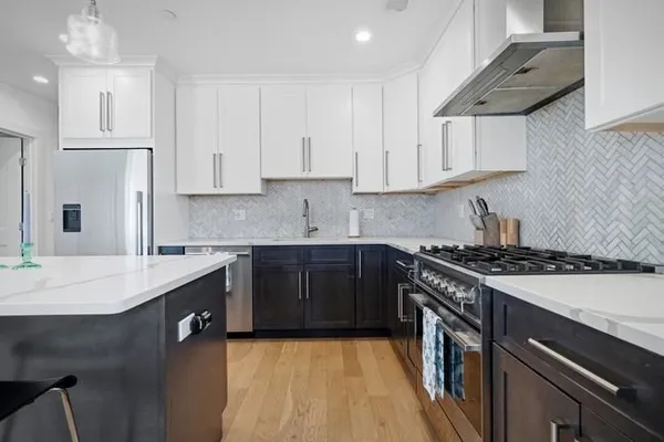 a kitchen with stainless steel appliances granite countertop a sink stove and cabinets