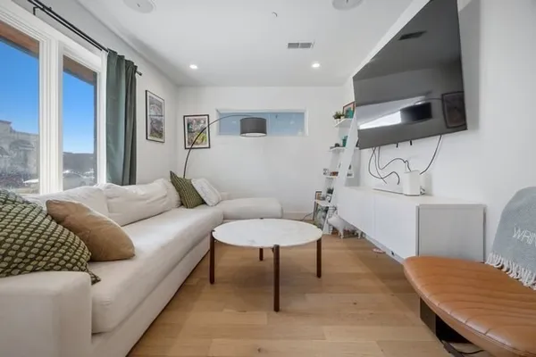 a living room with furniture a flat screen tv and a window