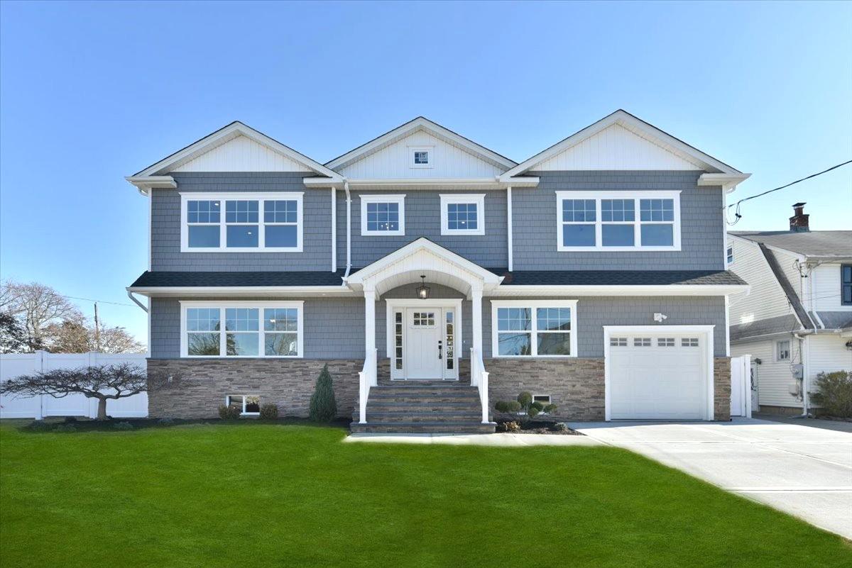 801 Pine Place Bellmore, NY 11710 - Photo 1 of 1 View of front of house with a garage and a front yard