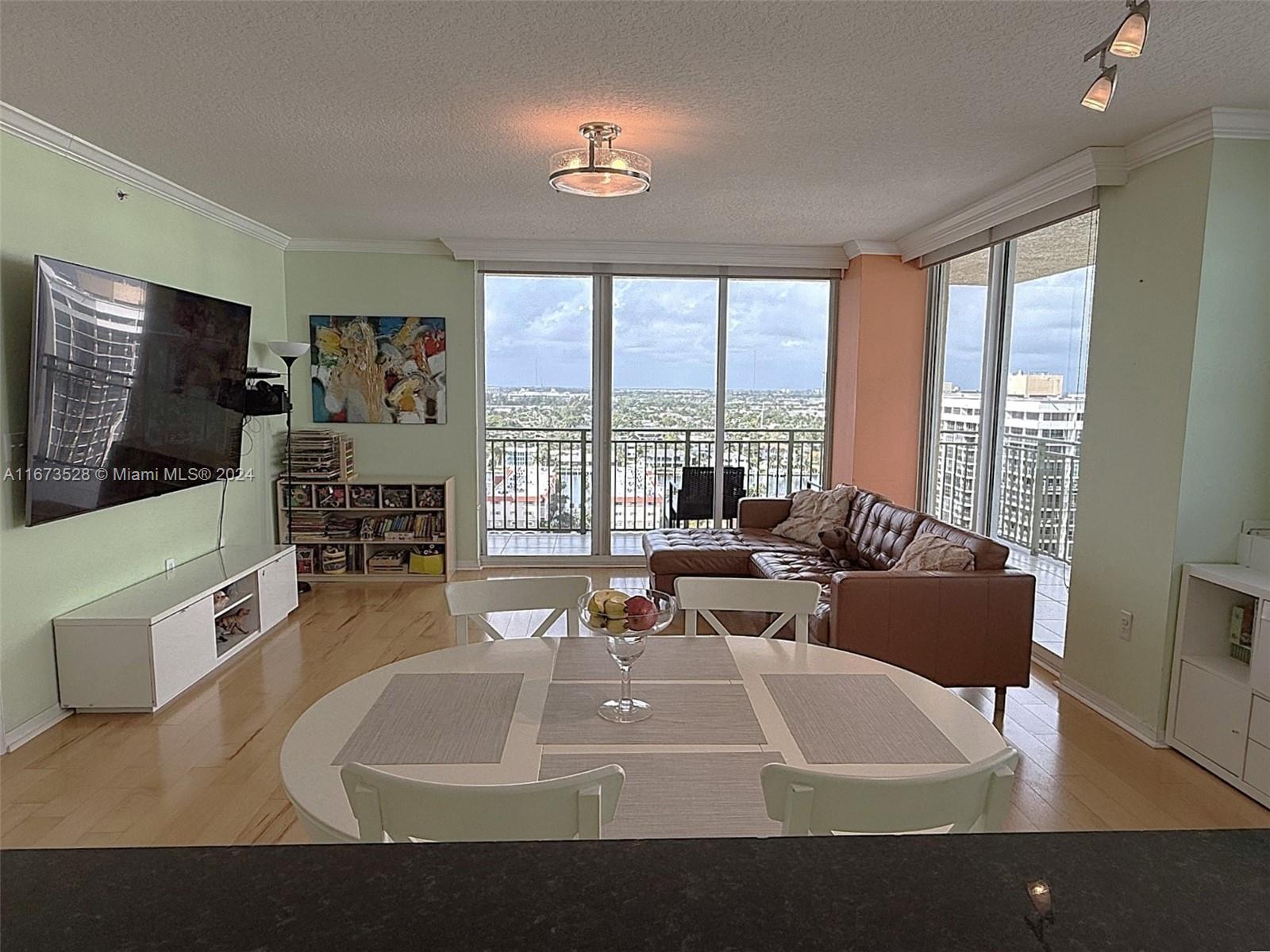 2080 South Ocean Drive, Unit 1602 Hallandale Beach, FL 33009 - Photo 4 of 38 a living room with furniture and a flat screen tv