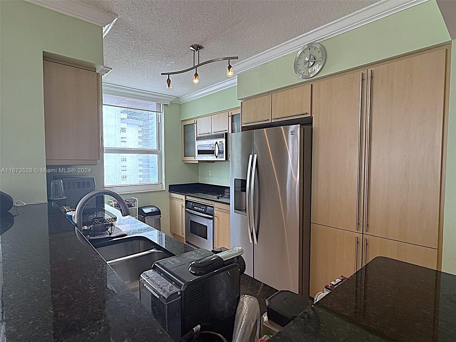 2080 South Ocean Drive, Unit 1602 Hallandale Beach, FL 33009 - Photo 6 of 38 a kitchen with refrigerator and window