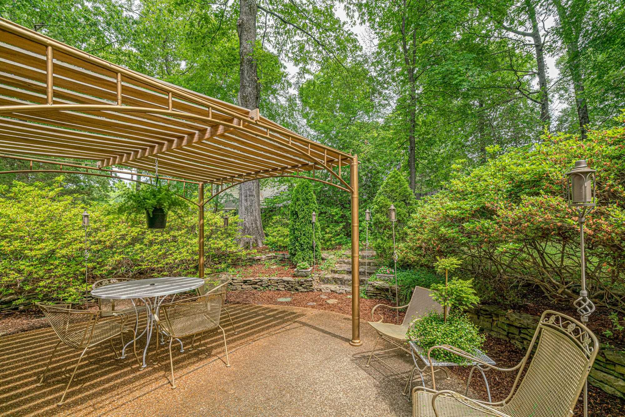 490 Brook Ridge Circle Memphis, TN 38018 - Photo 23 of 25 a backyard of a house with table and chairs under an umbrella