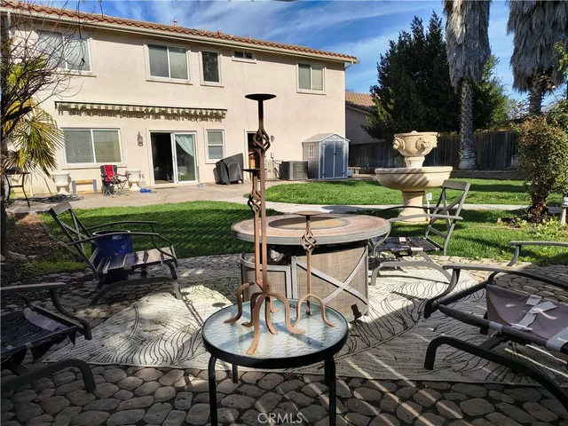 a view of a patio with table and chairs potted plants and large tree