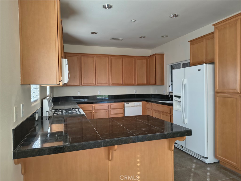 725 Petersen Ranch Road Templeton, CA 93465 - Photo 4 of 6 a kitchen with stainless steel appliances granite countertop a refrigerator a stove and a sink with wooden floor