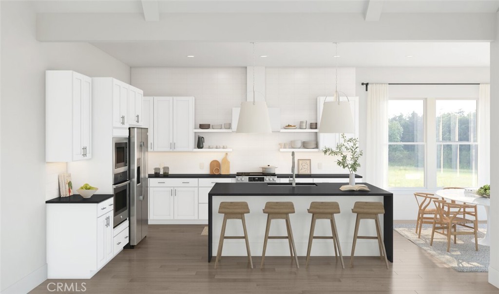 17244 Ta-Ki-Pi Road Apple Valley, CA 92307 - Photo 3 of 15 a kitchen with stainless steel appliances granite countertop a stove a sink a refrigerator and white cabinets with wooden floor
