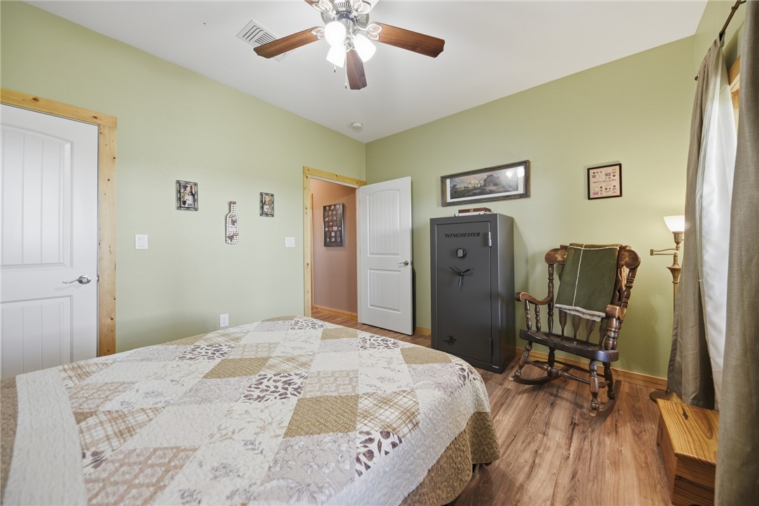 126 South Berlin Road Brenham, TX 77833 - Photo 22 of 30 a bedroom with a bed and wooden floor