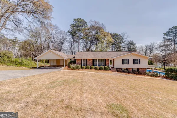 a front view of a house with yard and trees