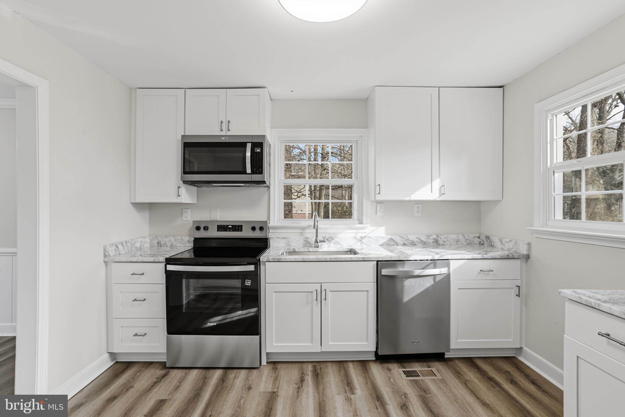 192 East Banbury Road Tappahannock, VA 22560 - Photo 19 of 50 a kitchen with stainless steel appliances granite countertop a stove top oven a sink and white cabinets