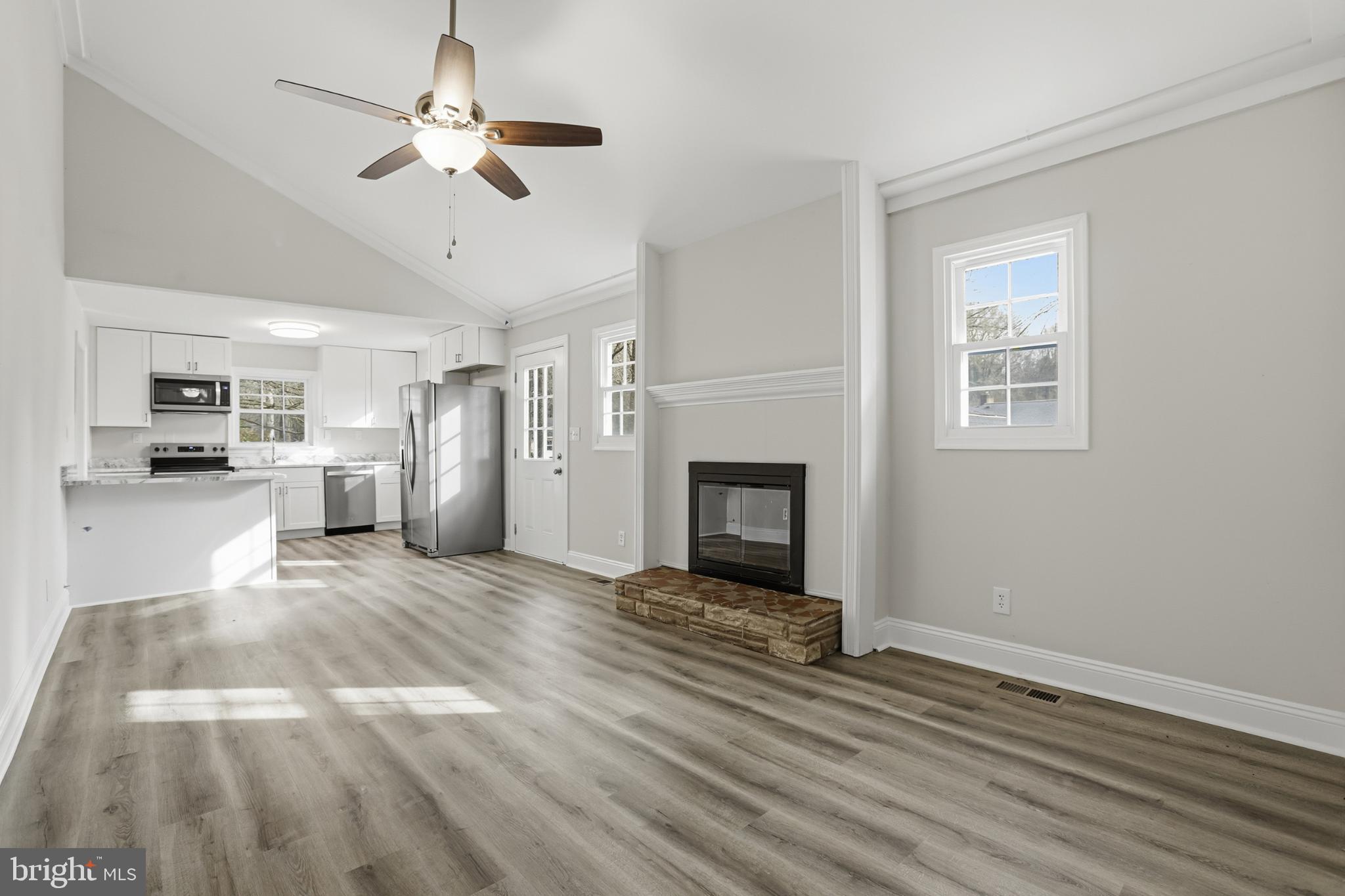 192 East Banbury Road Tappahannock, VA 22560 - Photo 24 of 50 a view of a livingroom with a fireplace a ceiling fan and wooden floor