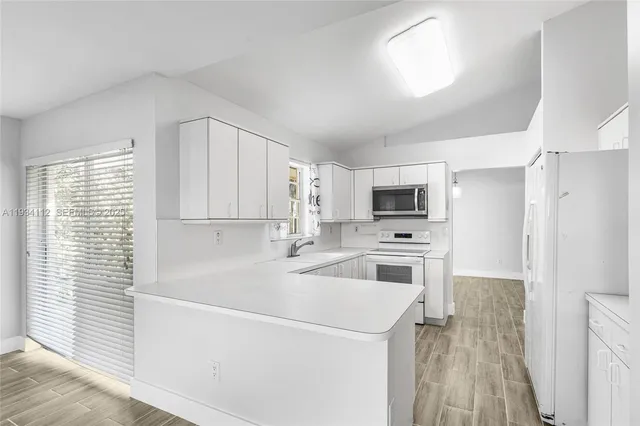 a kitchen with stainless steel appliances a refrigerator sink and microwave