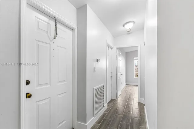 a view of a hallway with wooden floor