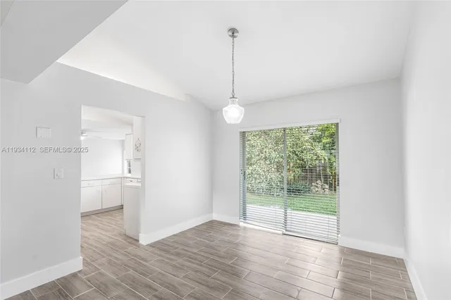 a view of a room with wooden floor and windows