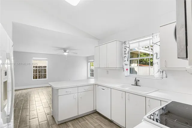 a kitchen with a sink cabinets and window