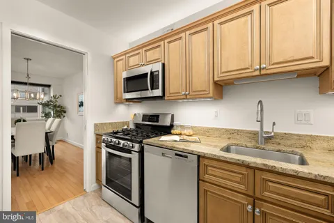 a kitchen with granite countertop a sink stainless steel appliances and cabinets