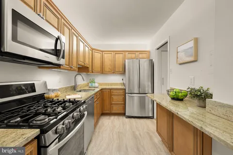 a kitchen with stainless steel appliances a stove a sink and a refrigerator