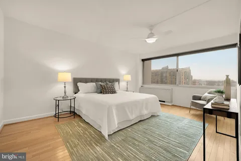 a bedroom with a bed and a large window