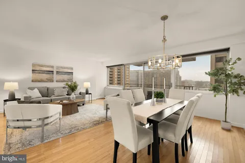 a dining room with furniture wooden floor a chandelier and a rug