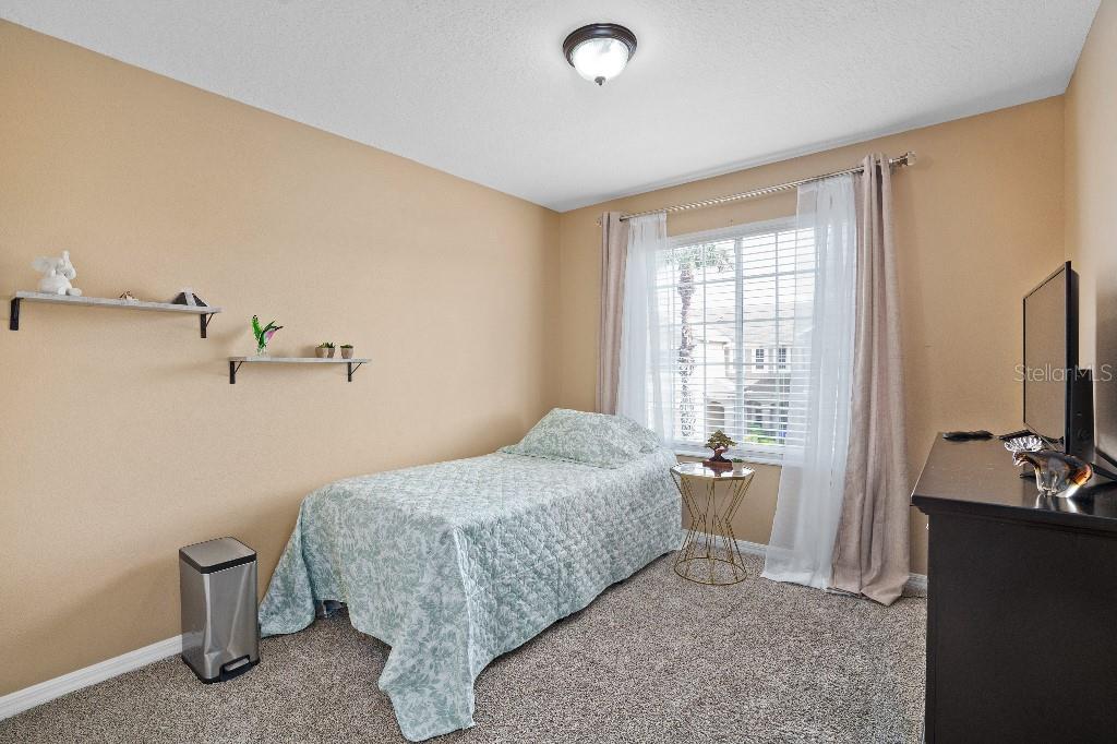 2417 Passamonte Drive, Unit 1E Winter Park, FL 32792 - Photo 12 of 15 a bedroom with a bed and a flat tv screen on dresser