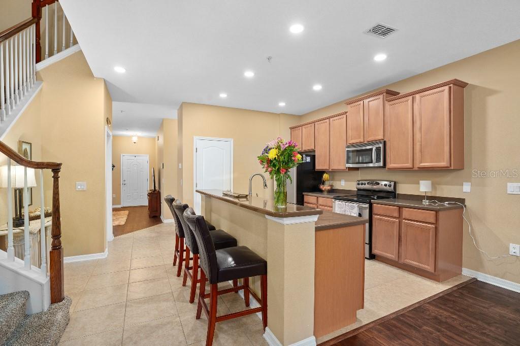 2417 Passamonte Drive, Unit 1E Winter Park, FL 32792 - Photo 3 of 15 a kitchen with stainless steel appliances kitchen island granite countertop a refrigerator and microwave