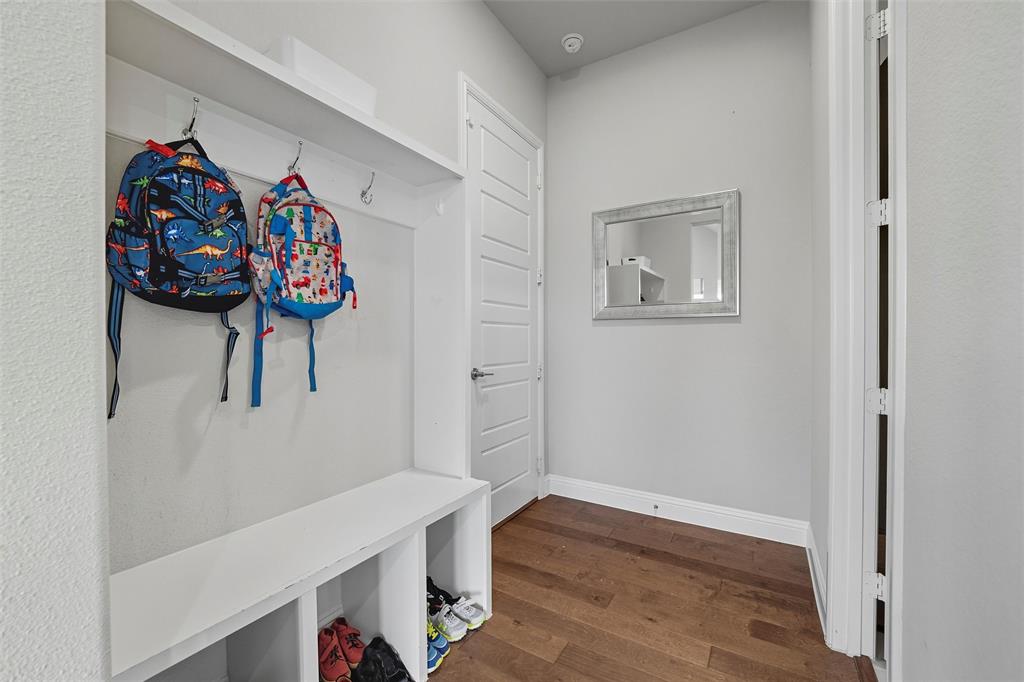 8492 Chapote Road Frisco, TX 75035 - Photo 20 of 40 Mudroom features built-in bench with cubbies and upper shelf with hooks for storage. Wide-plank hardwood flooring extending through the space.
