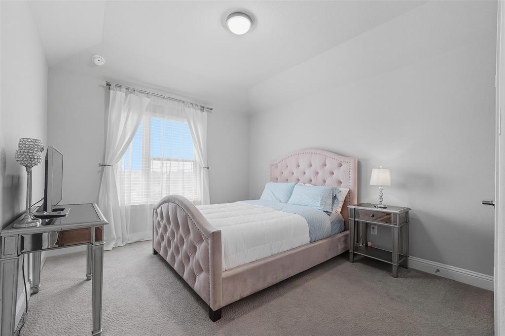 8492 Chapote Road Frisco, TX 75035 - Photo 27 of 40 Secondary Bedroom features vaulted ceiling with flush-mount light. Spacious layout with soft carpet flooring extending through the space.