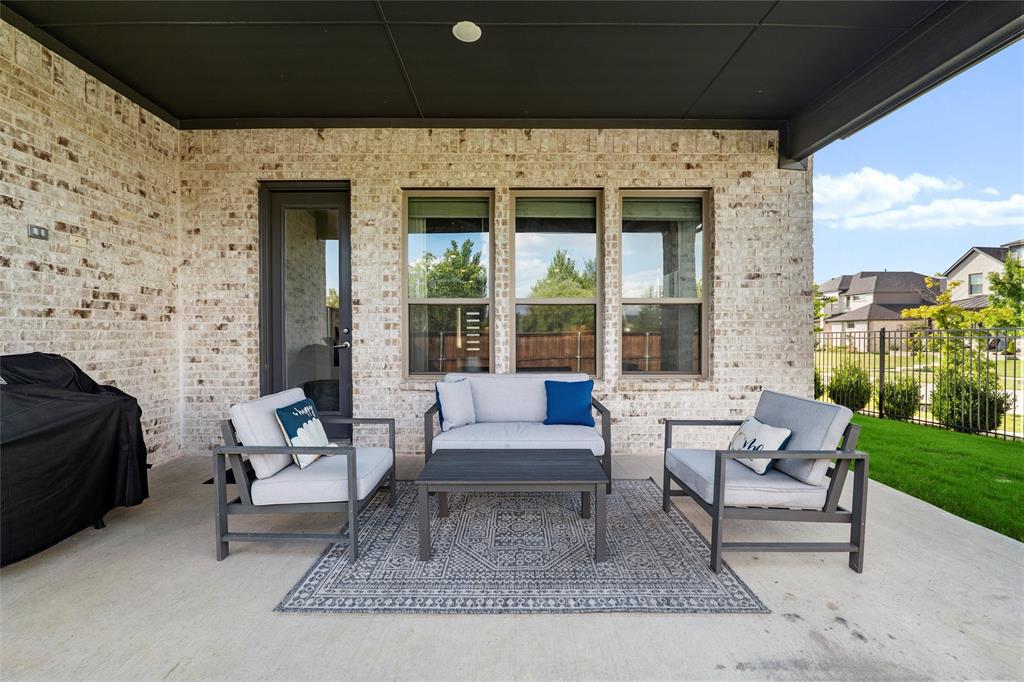 8492 Chapote Road Frisco, TX 75035 - Photo 29 of 40 Covered Patio features dark ceiling with recessed light and extended overhang supported by brick columns. Concrete flooring with space for outdoor seating.