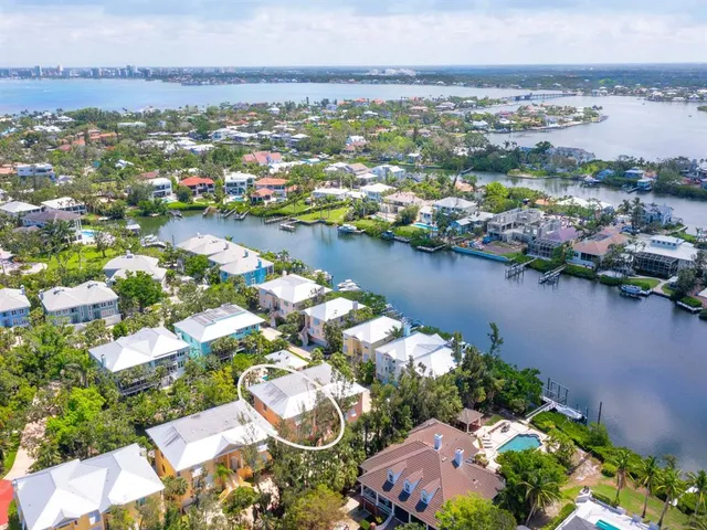 an aerial view of residential houses with outdoor space and lake view