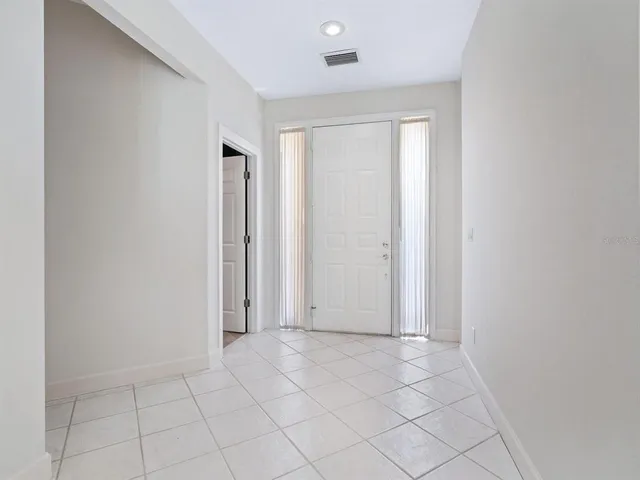 a view of a big room with windows and chandelier fan