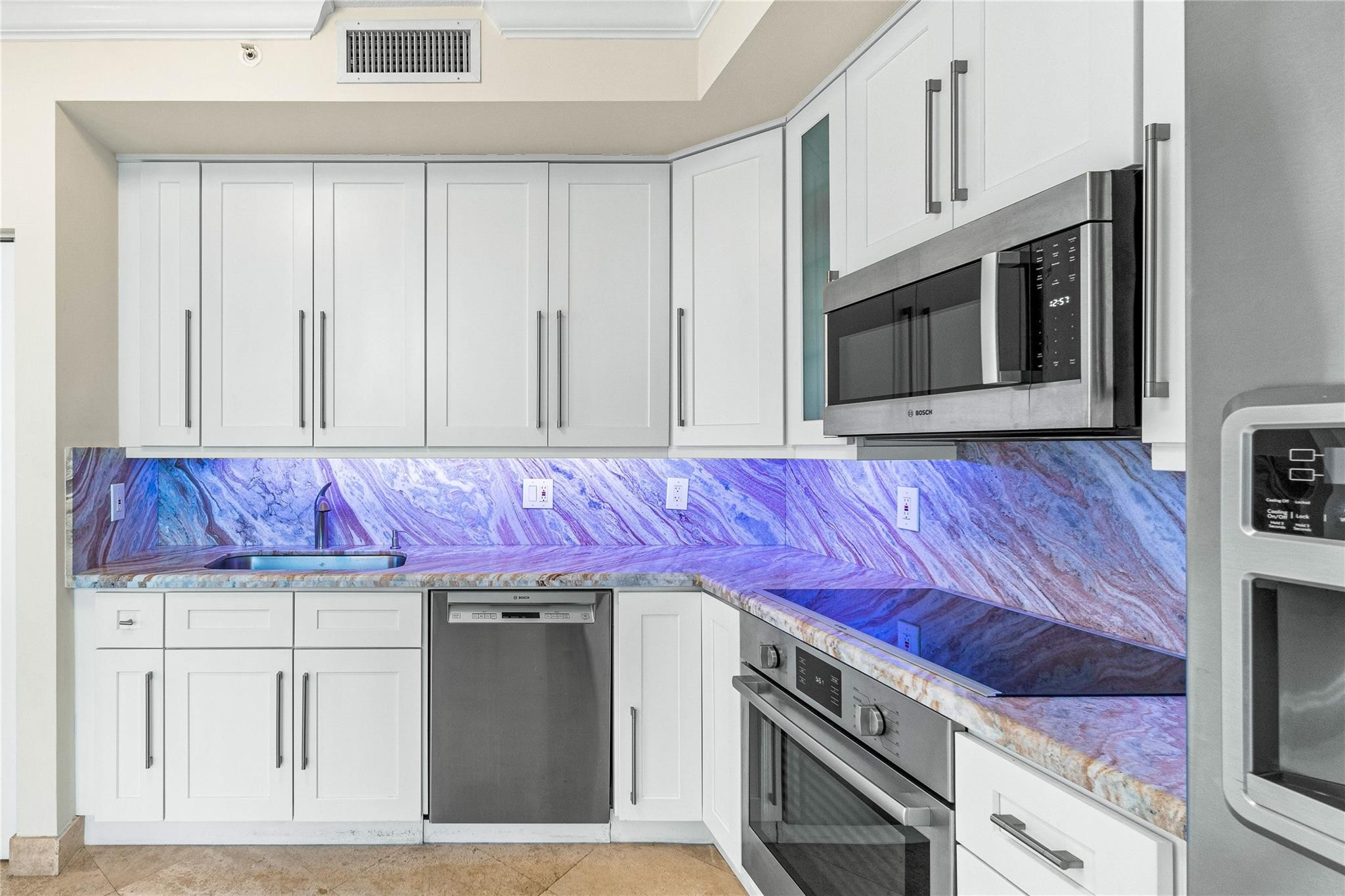 100 South Birch Road, Unit 904 Fort Lauderdale, FL 33316 - Photo 18 of 51 a kitchen with stainless steel appliances granite countertop a stove and a microwave